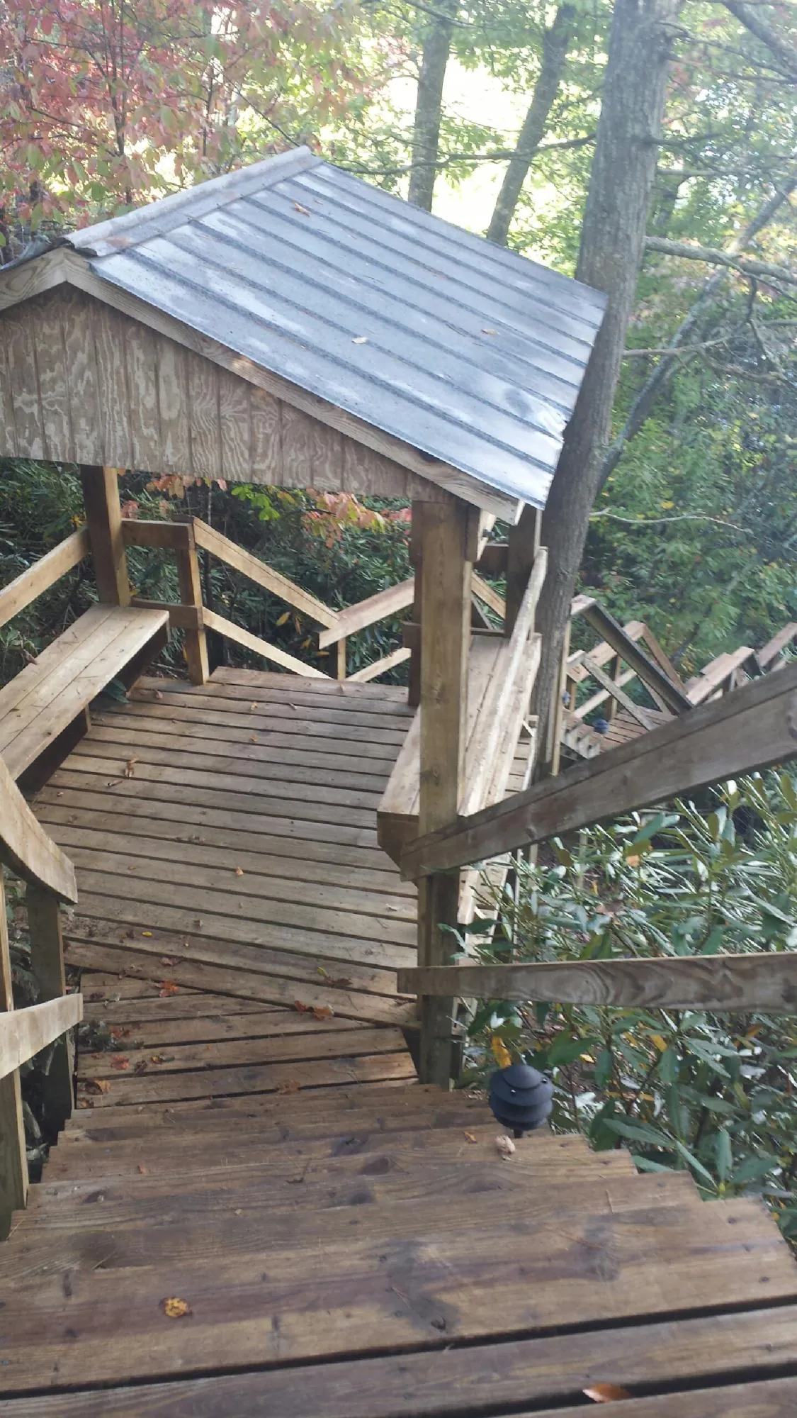 Metal roofed shelter over wooden steps on a wooded walkway — Skylight Repair & Installation work by our crew in Olivebridge